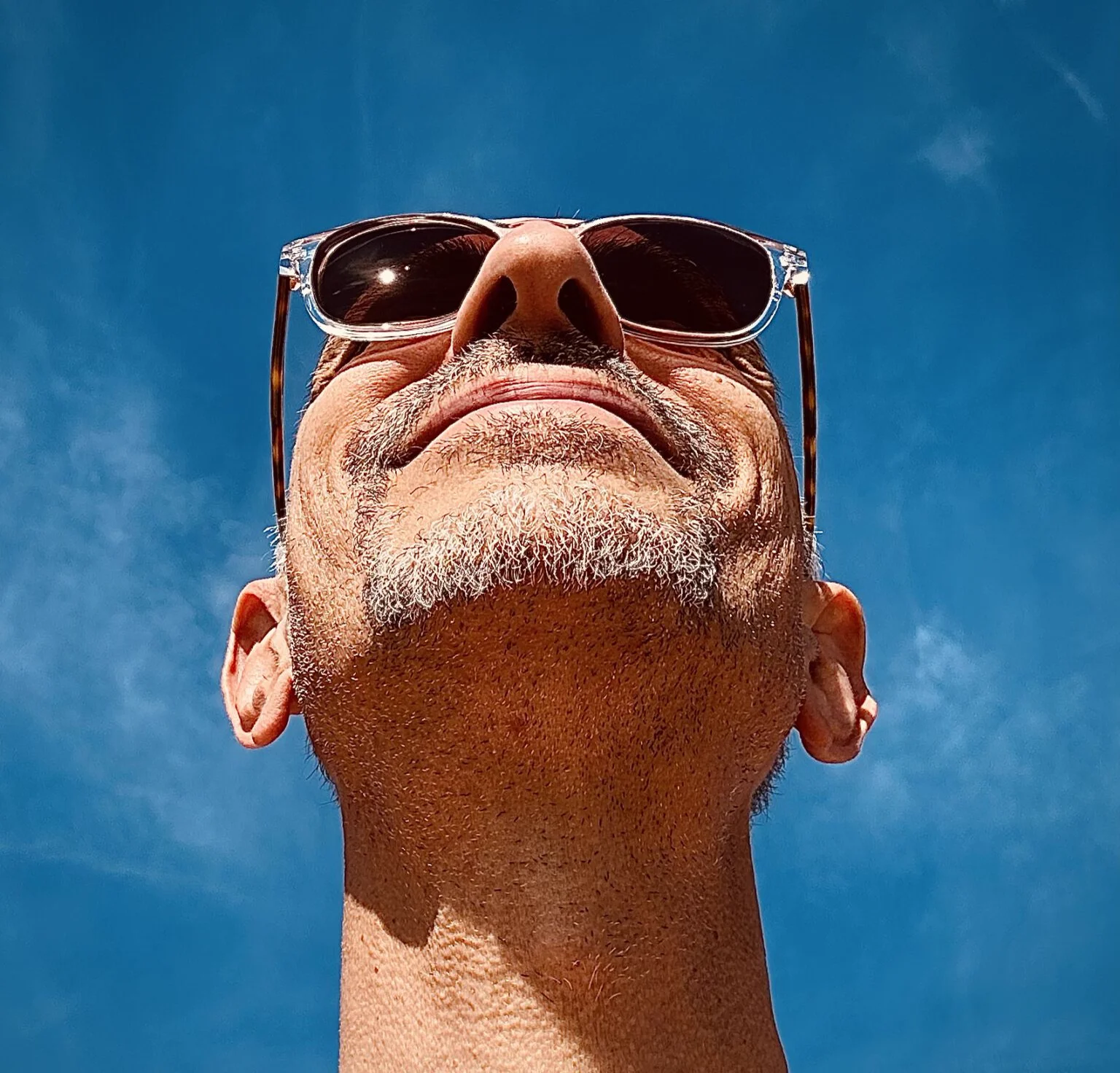 Thomas mit Sonnenbrille vor blauem Himmel